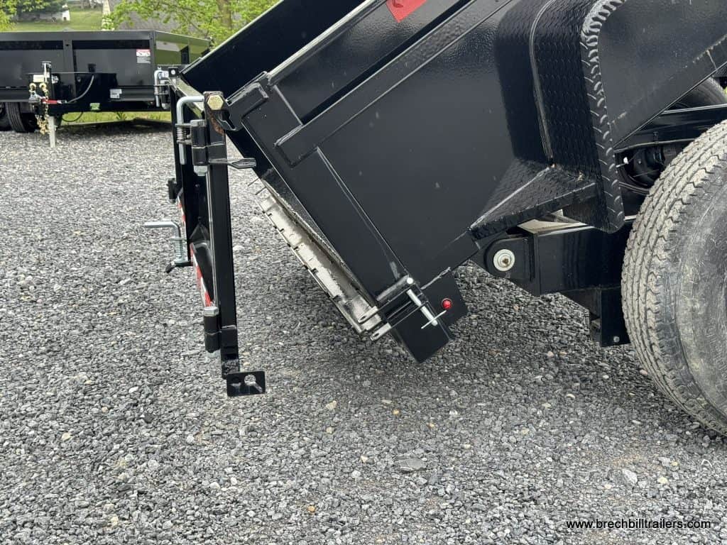 The trailer tilted for dumping and the spread gate open.