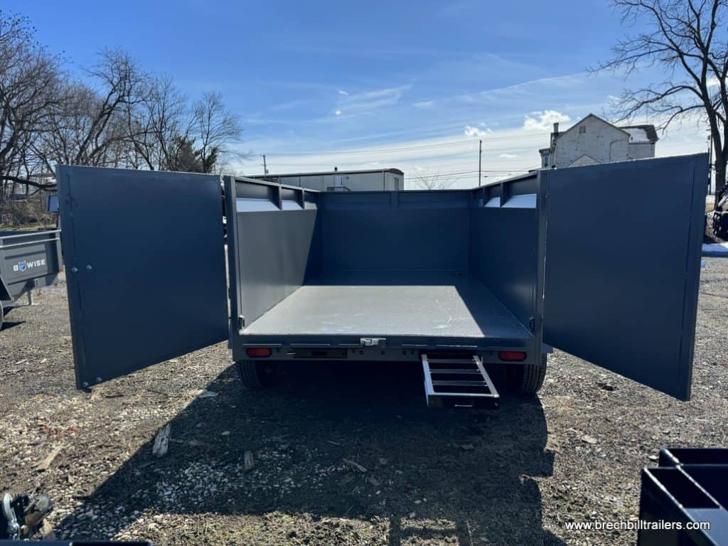 Looking in the Bwise High Side 12K Dump Trailer with a ramp sliding out for display.