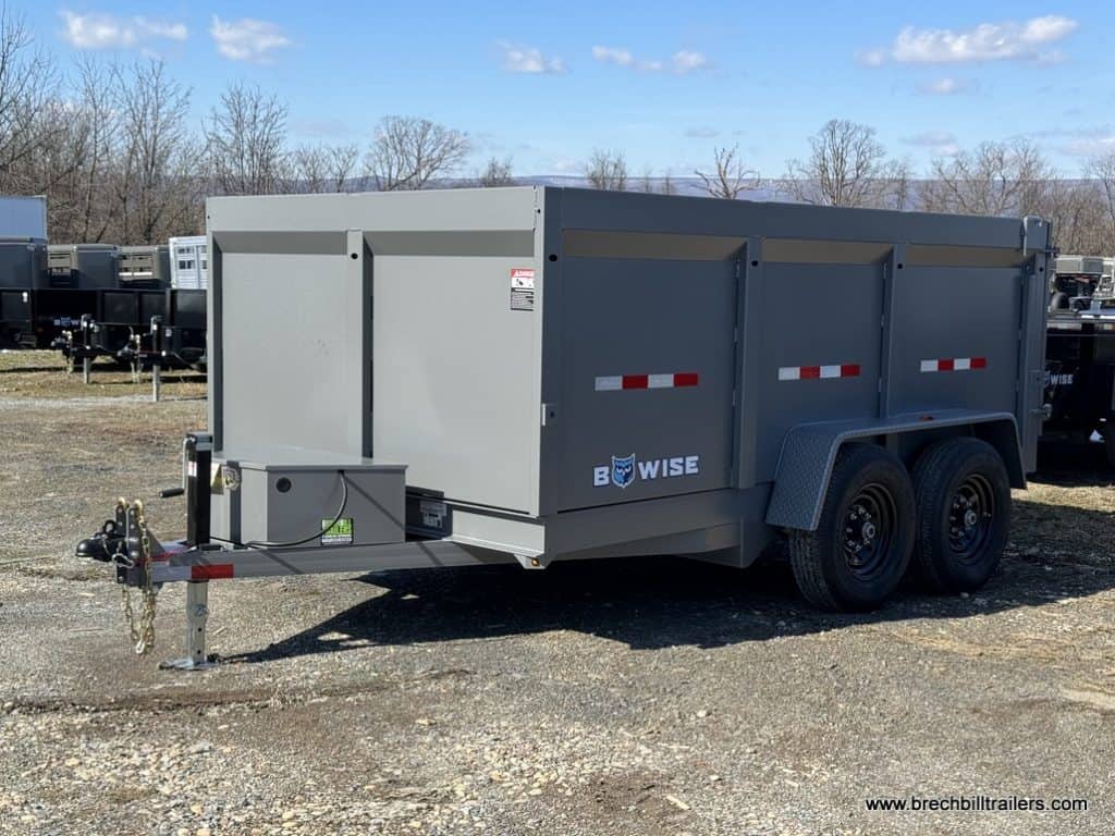Side view of a new Bwise High Side 12K Dump Trailer parked in the lot.