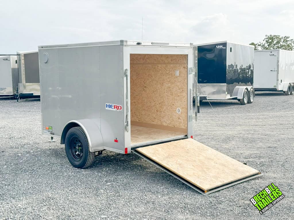 A silver Bravo Hero Enclosed Cargo Trailer with the ramp down.