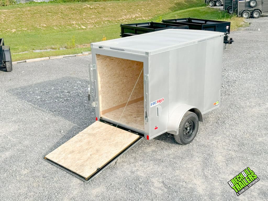 A 5x8 silver enclosed cargo trailer with a ramp door for easy loading and unloading.