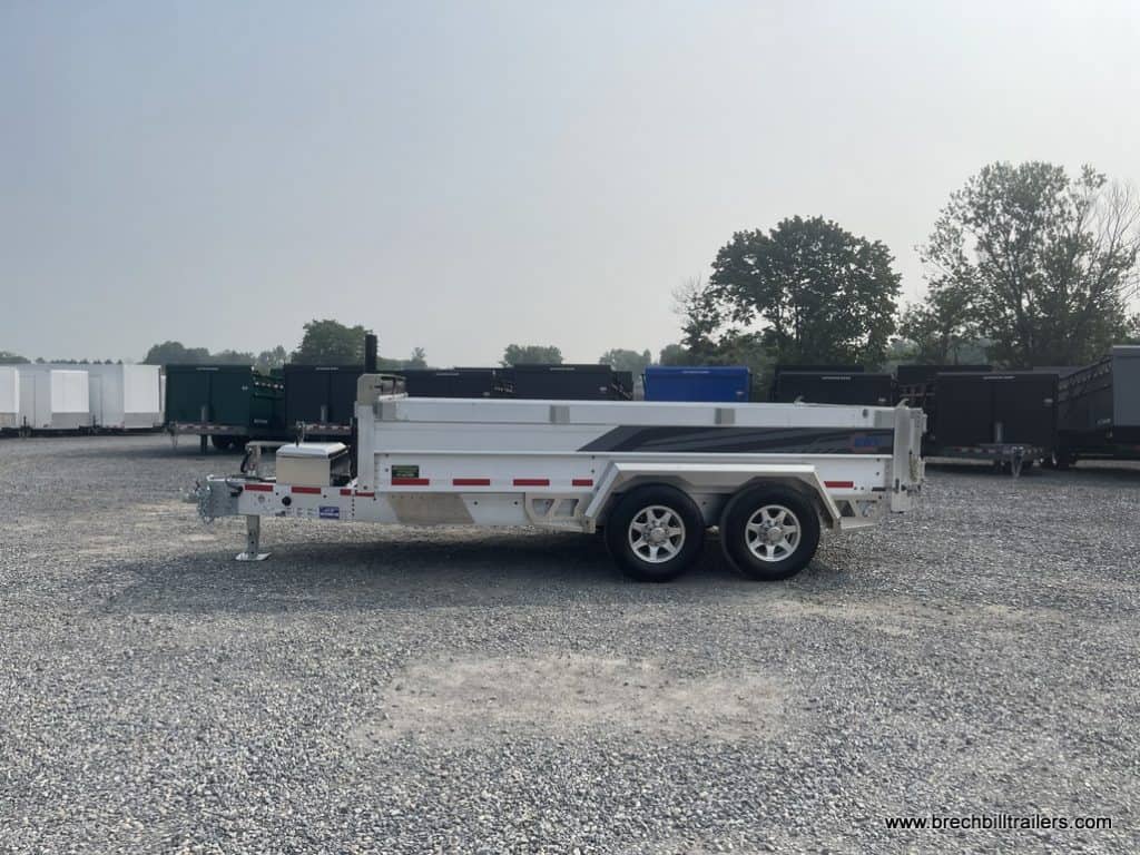 Side view of the EBY All Aluminum Bumper Pull Dump Trailer while its parked in the yard.