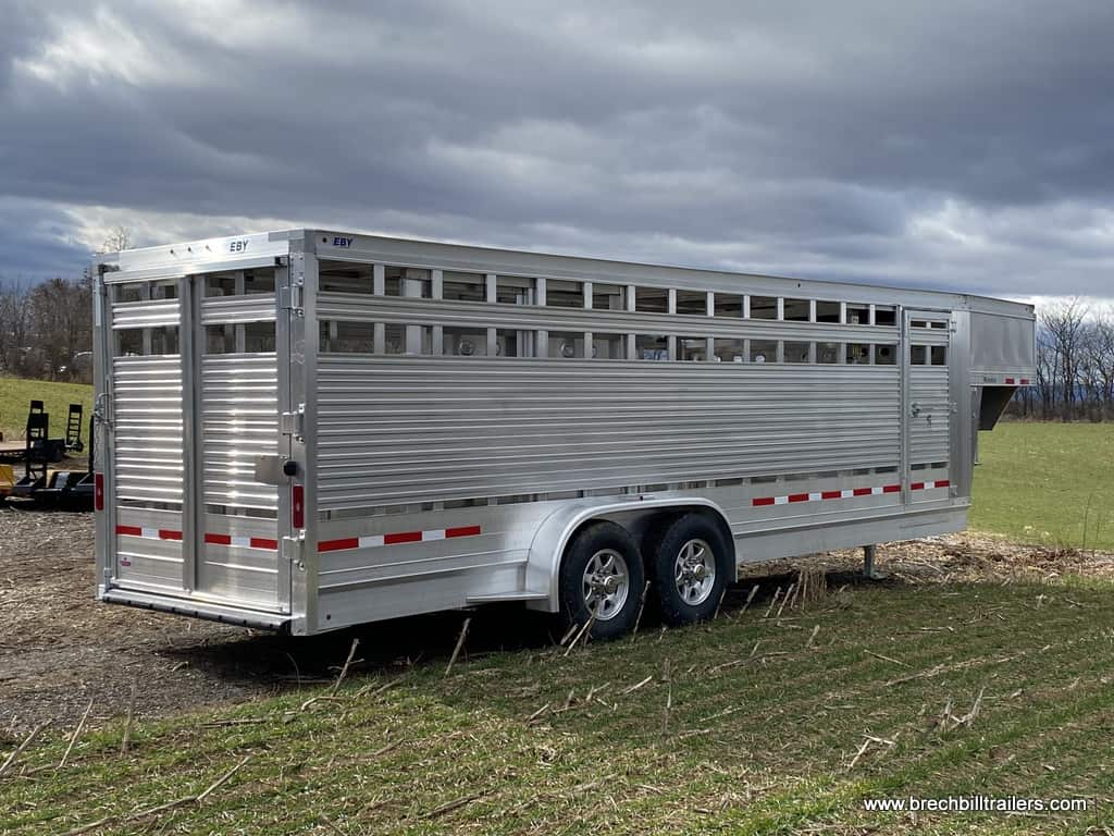 Brand new EBY Maverick 14K Gooseneck Livestock Trailer parked in a yard.
