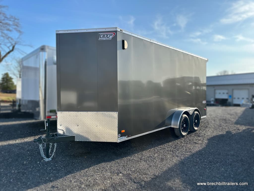 A charcoal gray Bravo Scout 7K Enclosed Cargo Trailer parked in the lot for sale