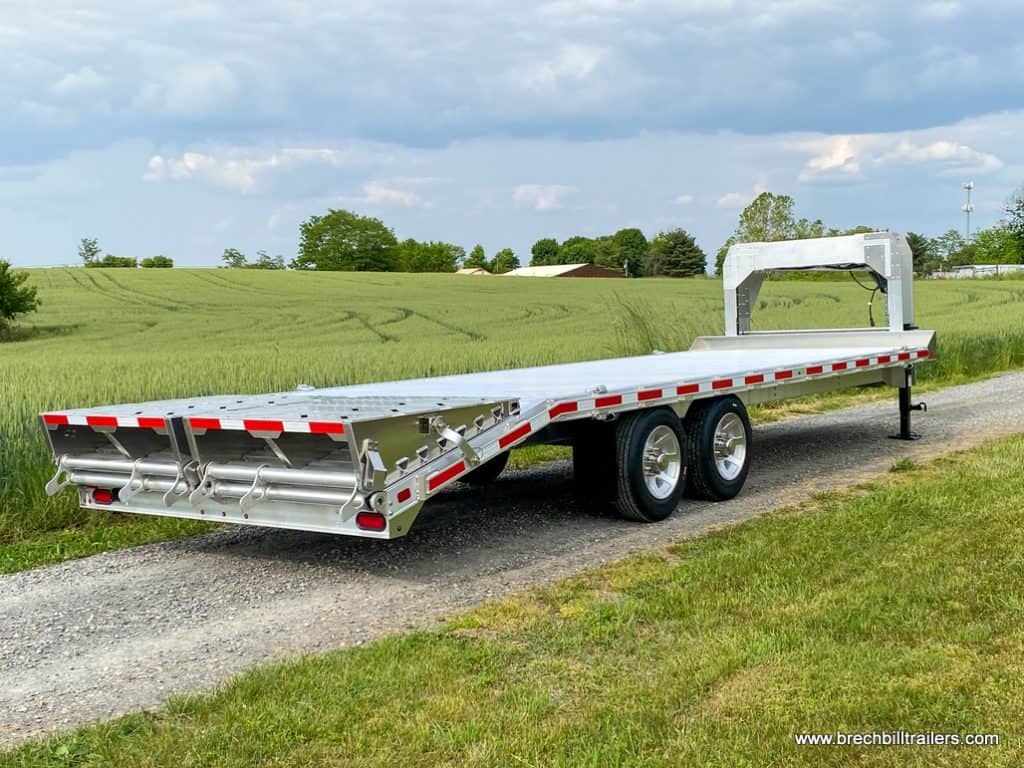 EBY 16K Deck-Over Gooseneck Equipment Trailer parked on a dirt road.