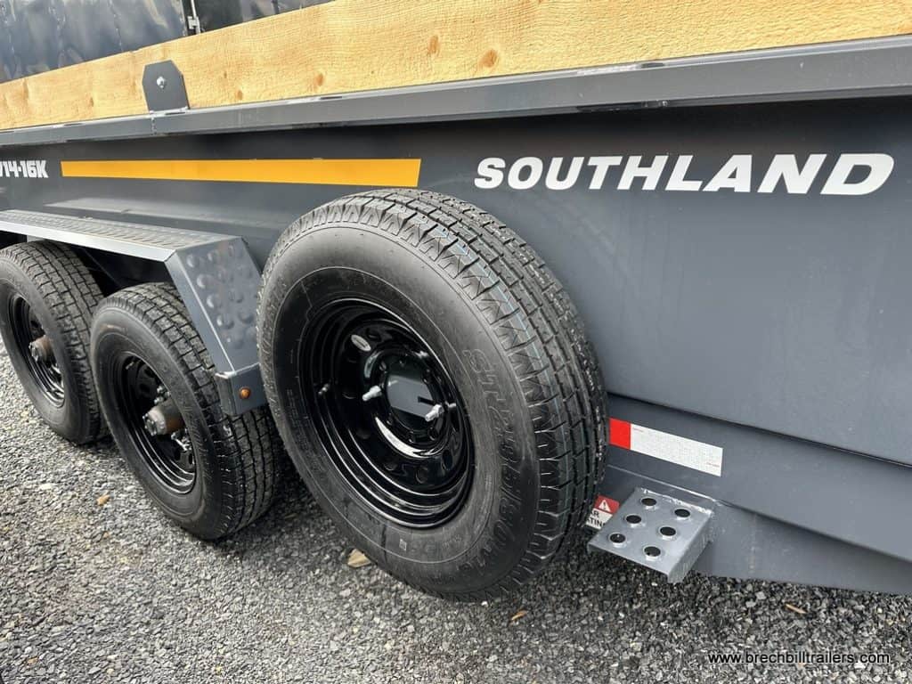 7x14 charcoal gray Southland 16K Tandem Axle Dump Trailer's spare tire mounted on the side.