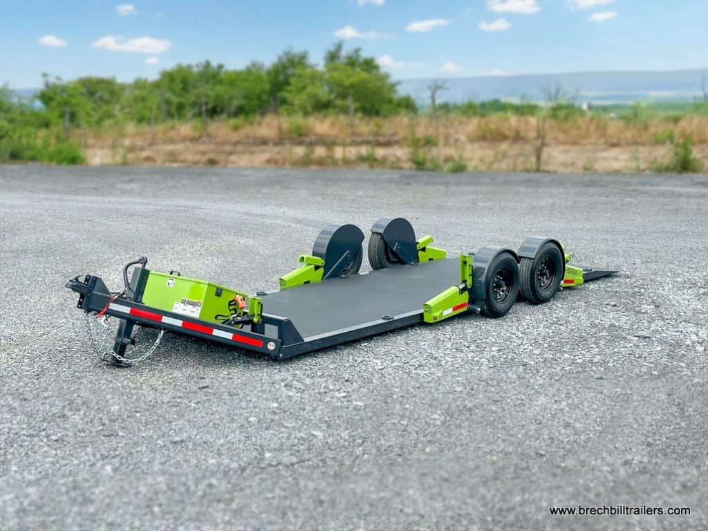 Blurred Background focusing on the high quality 22 foot FlatTrak Charcoal and Lime Green Equipment no ramps low clearance trailer 14k