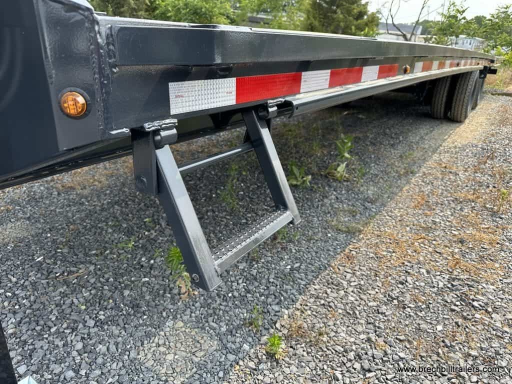 A step on the side of the Belmont 26K Hydraulic Dovetail Gooseneck Trailer