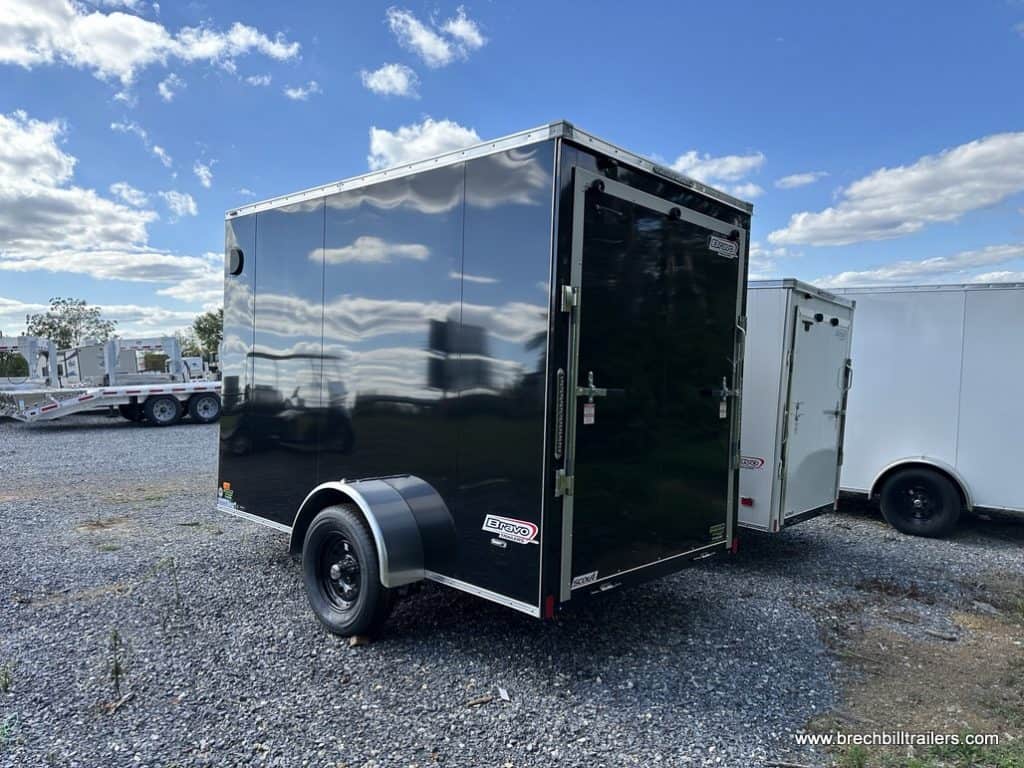 A Bravo 3K Scout Enclosed Cargo Trailer parked in the lot.