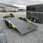 FlatTrak 7x18 Lay Flat 14K Equipment Hauler Trailer parked next to a livestock trailer