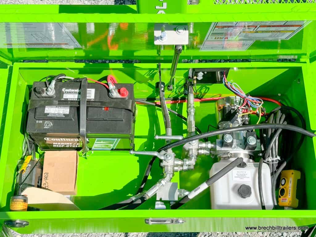 Inside the battery and hydraulic system box.