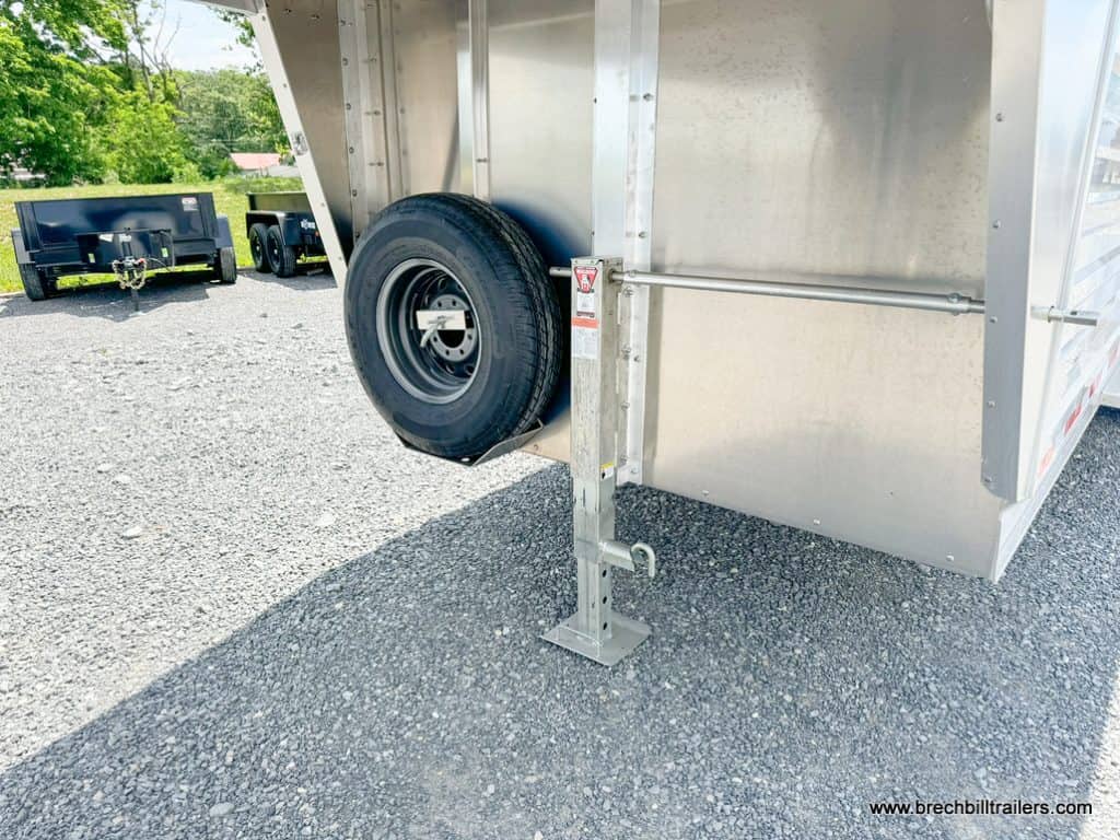 Spare wheel and jack on a parked EBY 14K Maverick Gooseneck Livestock Trailer