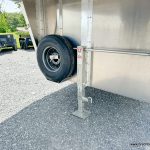 Spare wheel and jack on a parked EBY 14K Maverick Gooseneck Livestock Trailer
