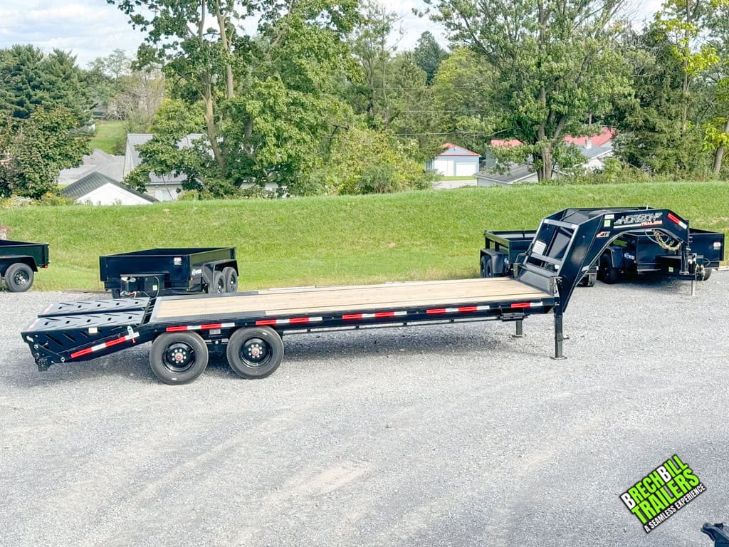 Side view of a Horizon 24ft Flatdeck Gooseneck Trailer parked at the dealership.