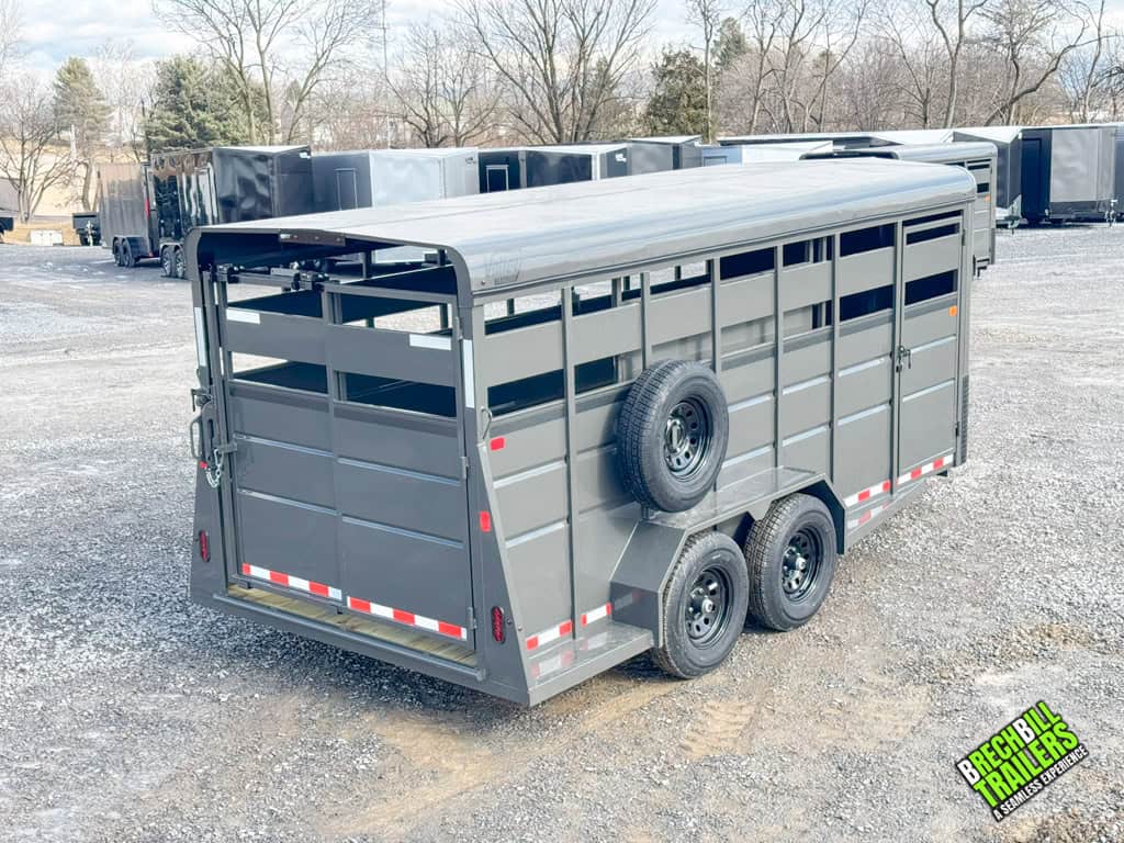 Side view showing the trailer's body with a spare wheel and windows for livestock