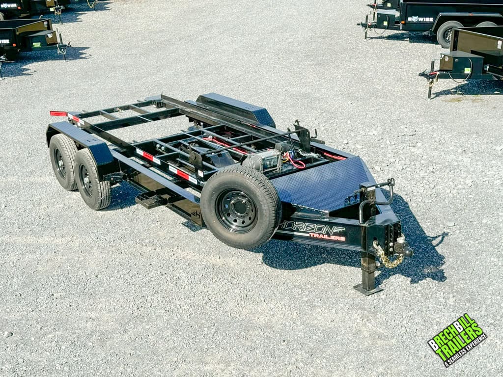 A brand new Horizon Roll Off Trailer in black with a spare wheel and dual axles.