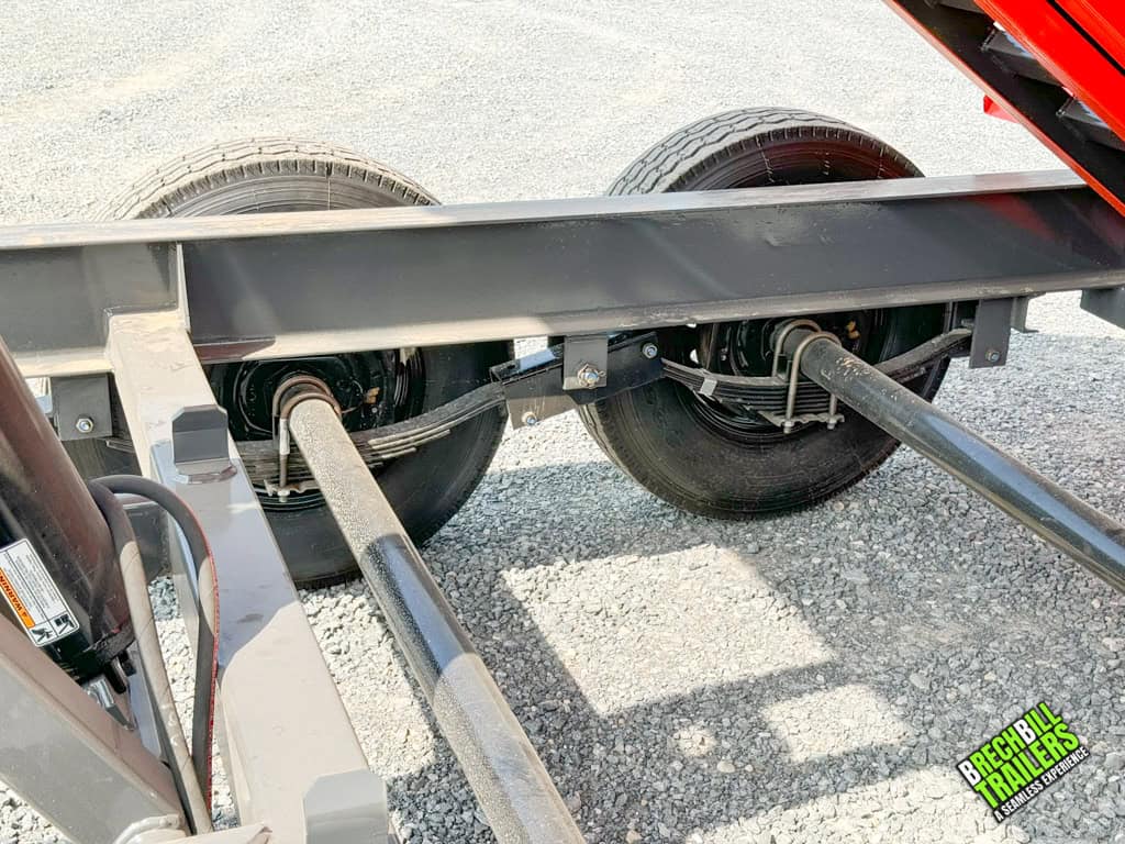 Axles and leaf suspension shown while the trailer is in the dump position.