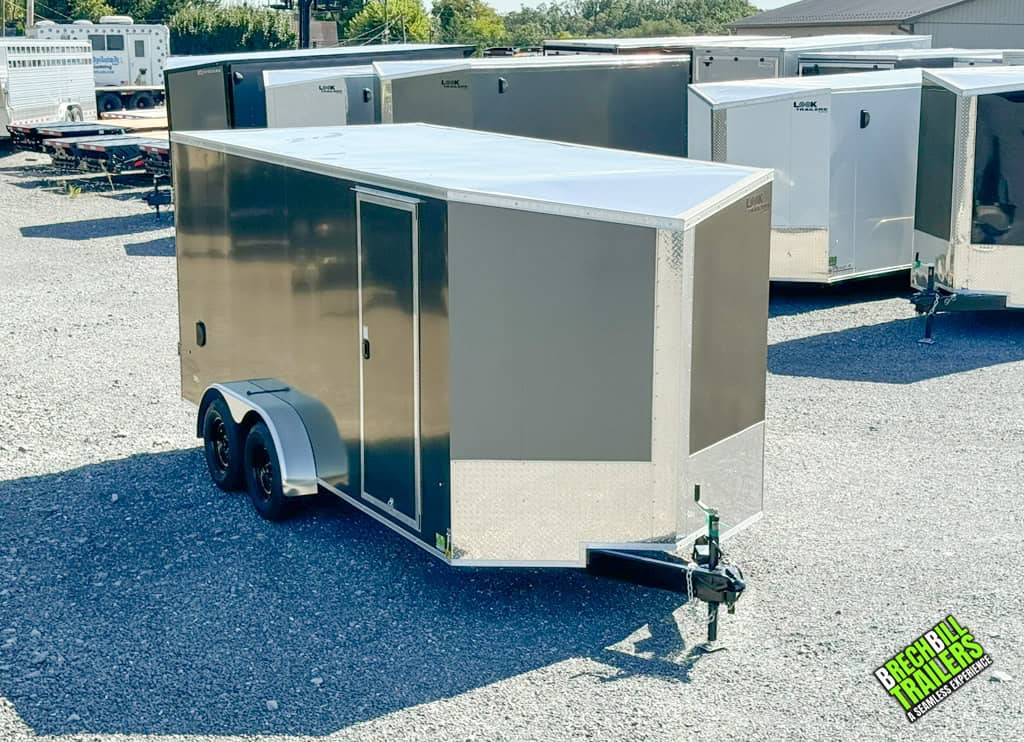 A parked charcoal black Look Element Enclosed Cargo Trailer with barn doors and black wheels.