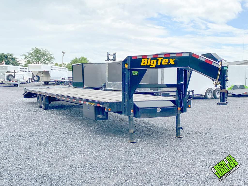 A black Used Big Tex 17.5K Tandem Gooseneck Trailer with a solid wood deck.