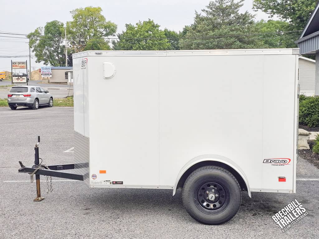 Used Bravo Scout Enclosed Cargo Trailer with white body and black wheels.