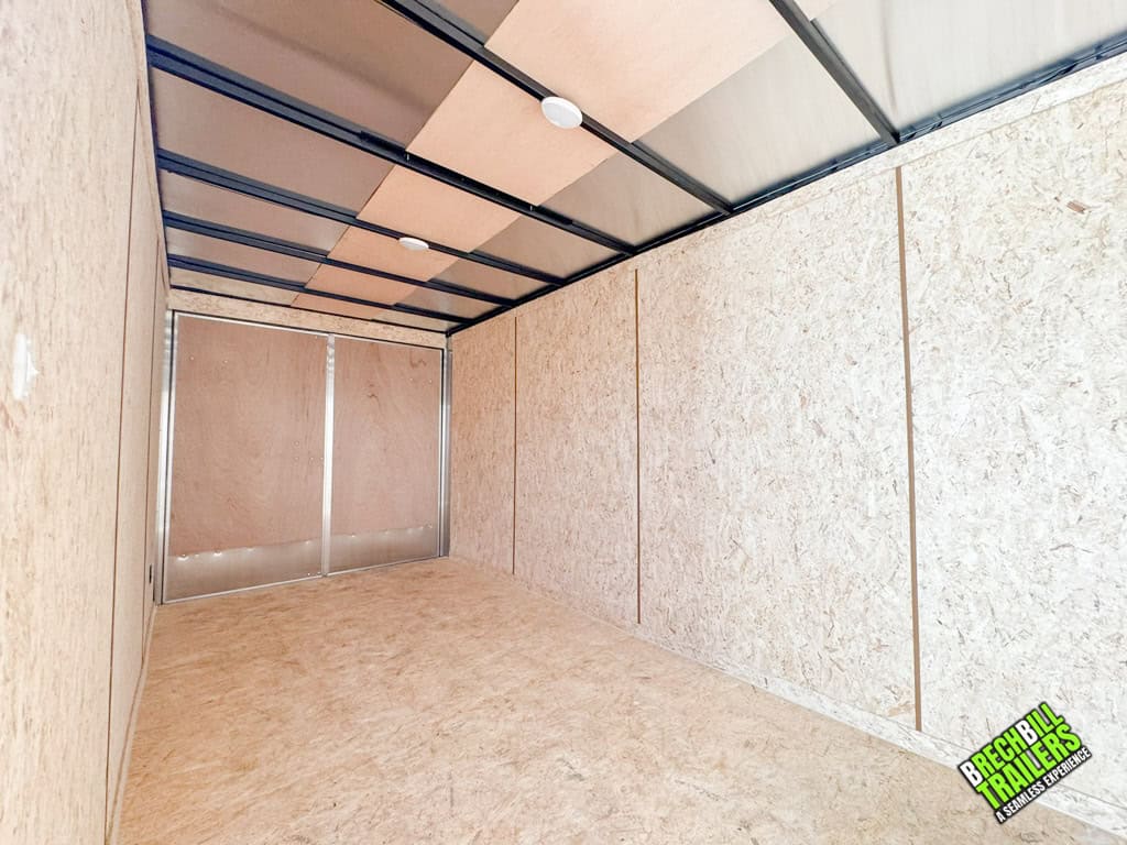 Inside a new Look LXT Enclosed Box Cargo Trailer with lighting and wood walls and floors.