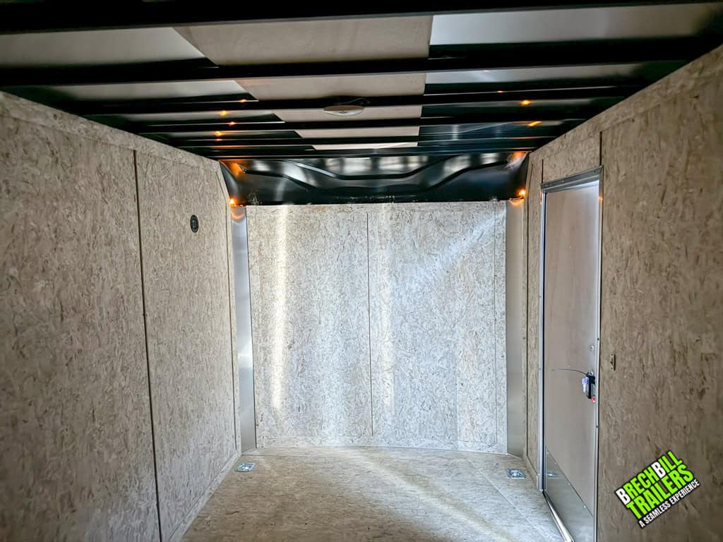Looking in the Look XLT Enclosed V-nose Cargo Trailer with light shining into the side door.