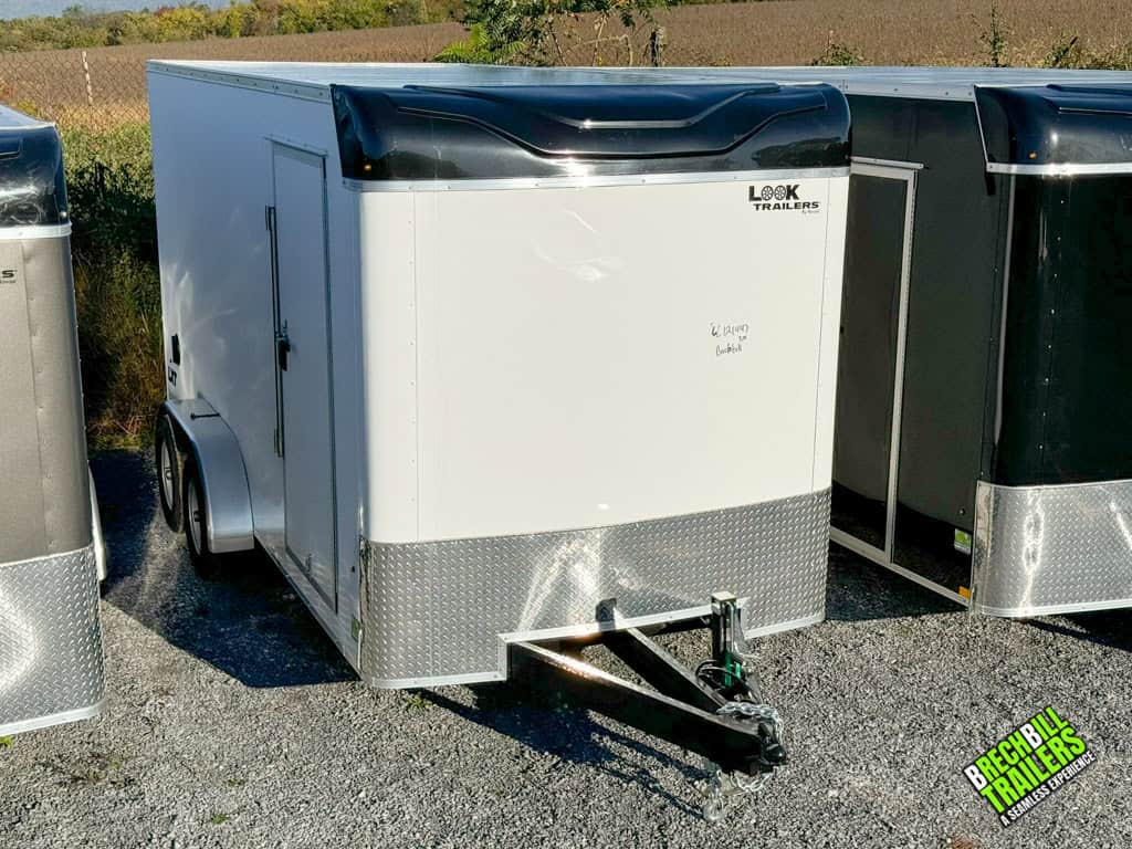 A parked Look XLT Enclosed V-nose Cargo Trailer for sale in white.