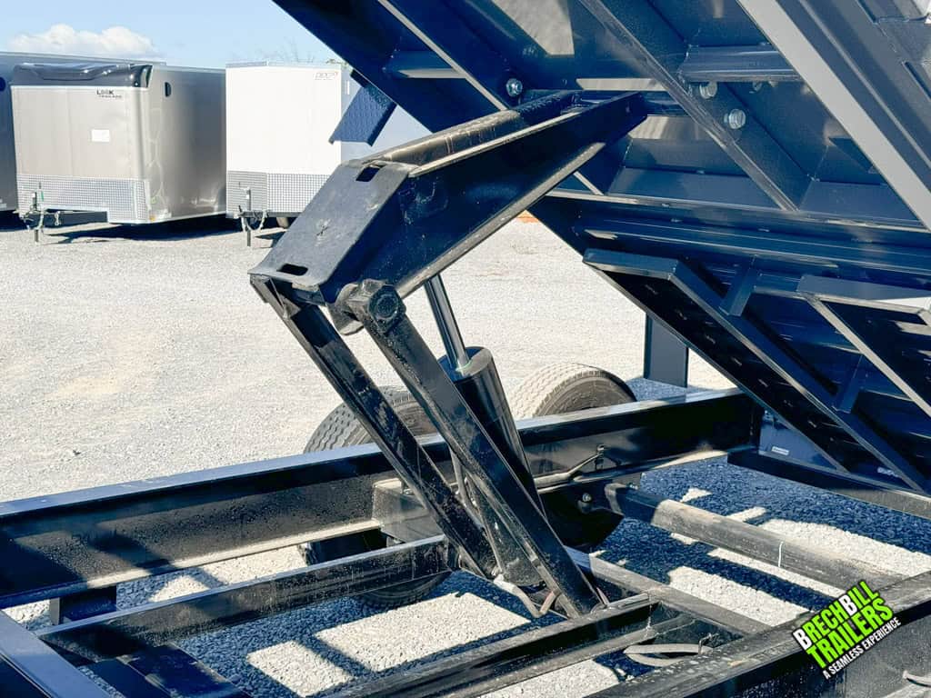 The hydraulic cylinder raising the dump trailer.