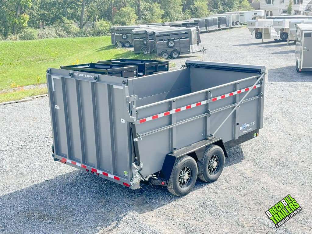 A rear view of the Bwise DU 15.4K Ultimate Dump Trailer on display at the dealership.