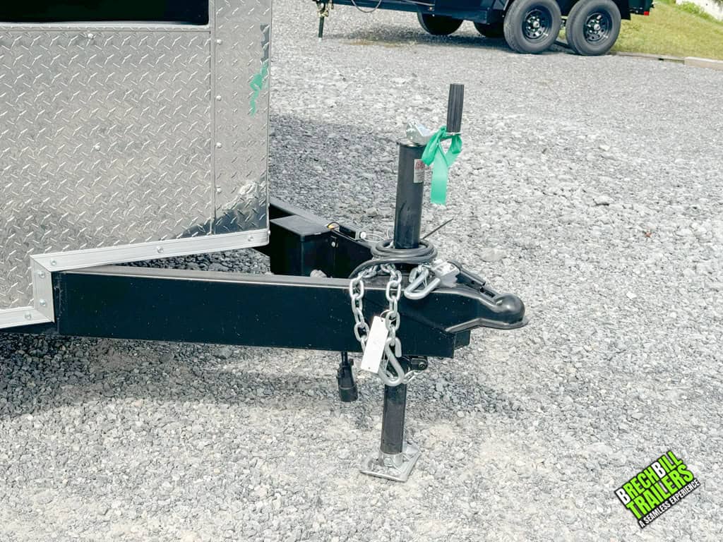 The coupler and the jack down on a new parked cargo trailer.