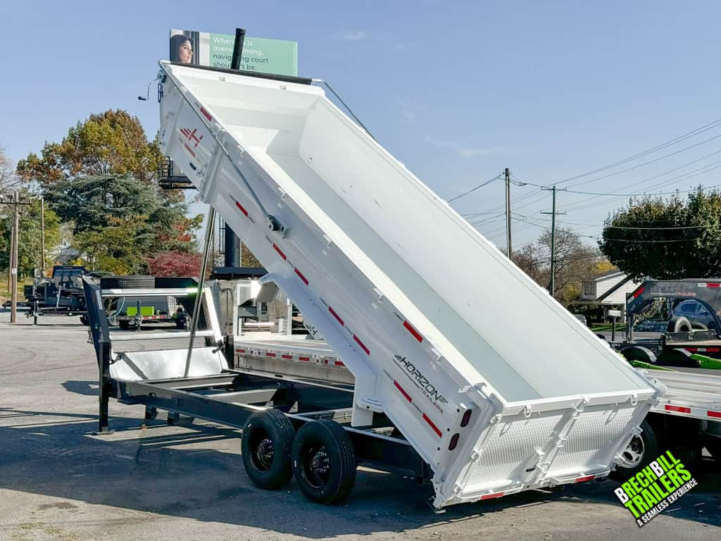 Full view of a white and grey Horizon gooseneck dump trailer in the dumping position