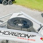Spare wheel mounted on the gray gooseneck trailer.