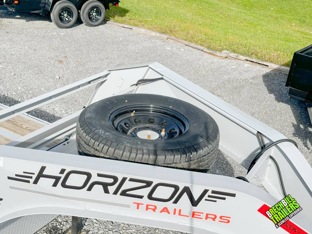 Spare wheel mounted on the gray gooseneck trailer.