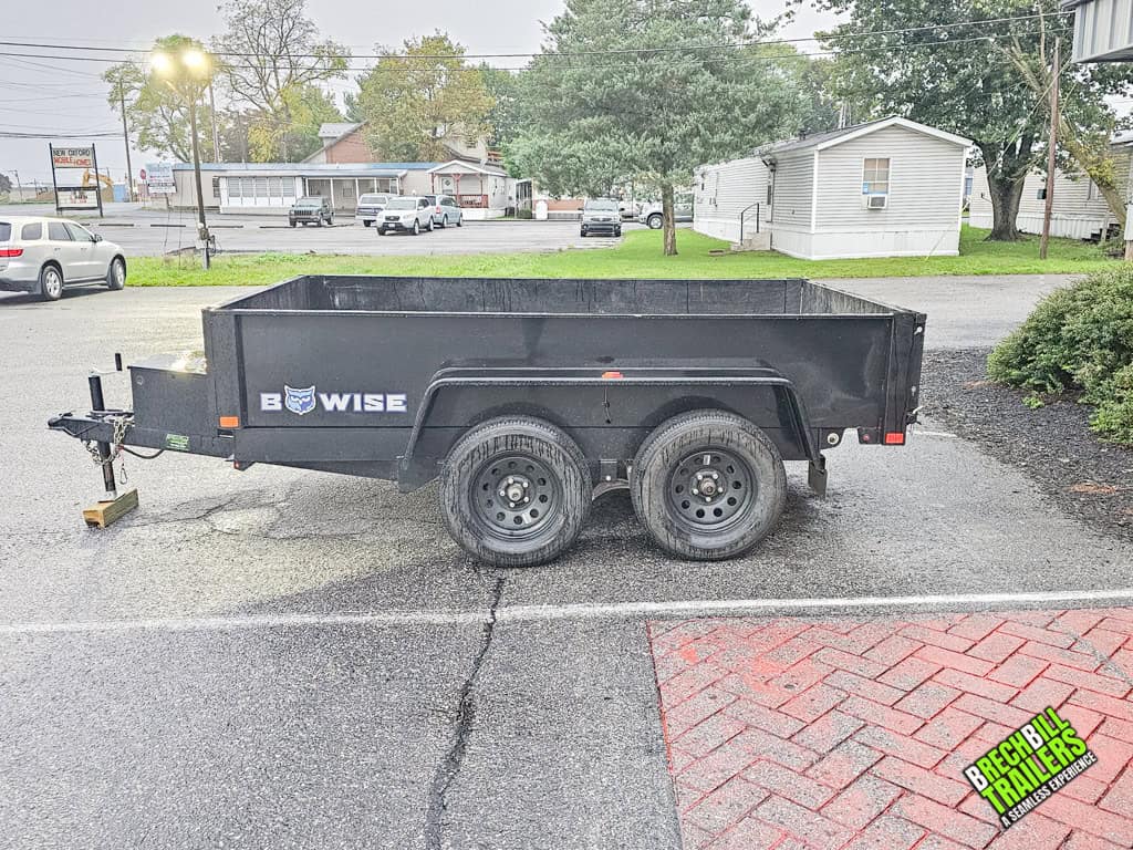 A Used Bwise R Series 7K Dump Trailer parked in a parking lot.