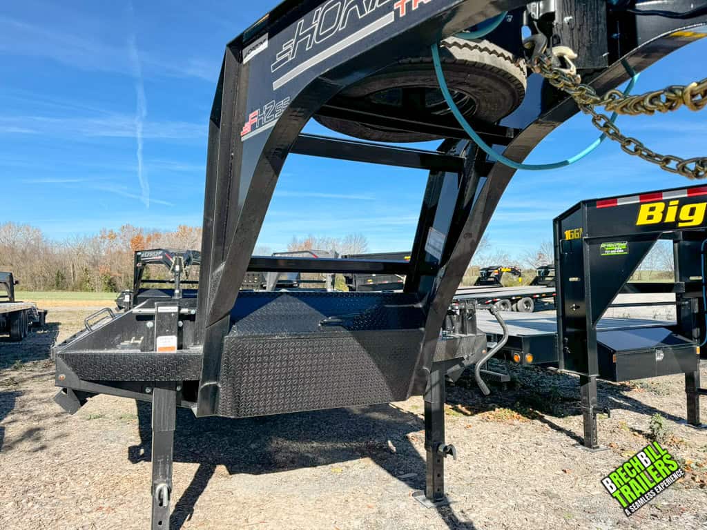 Black gooseneck hitch with spare tire mounted up top being held up by dual jacks.