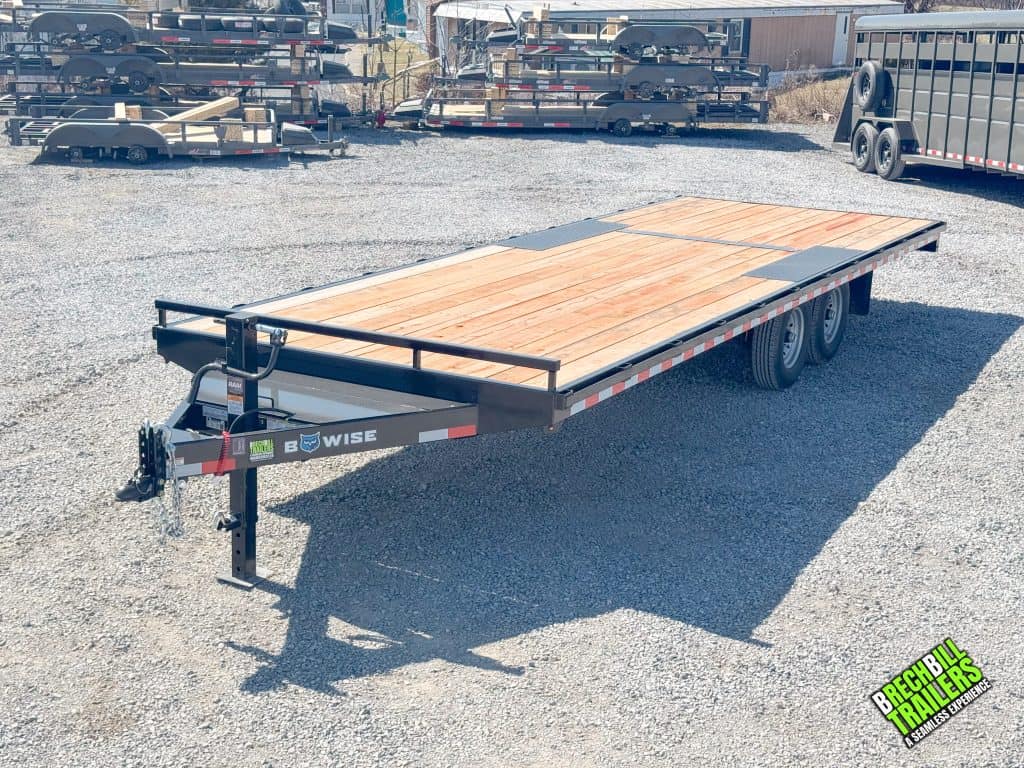 A Bwise 14k trailer with a 20ft long deck parked in the yard.